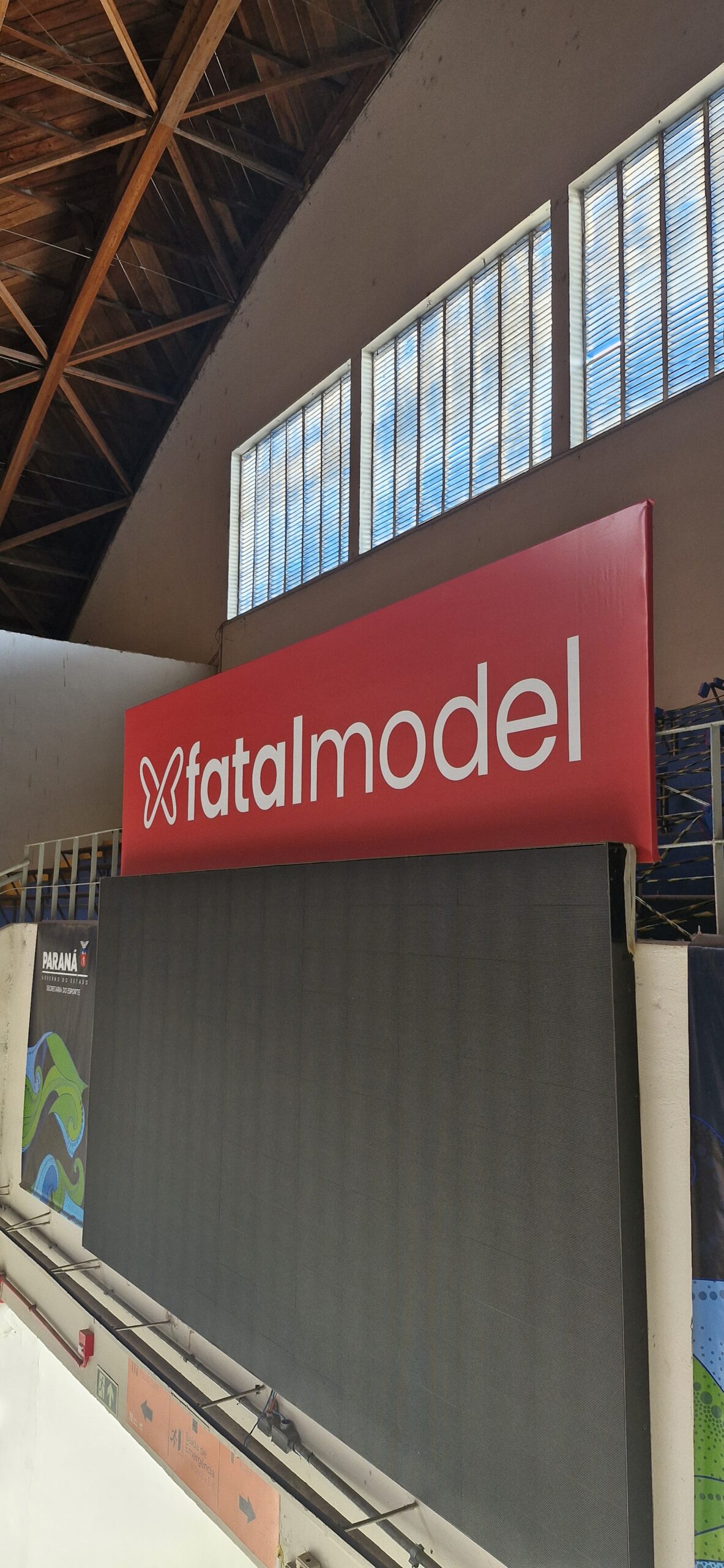 Banner em lona em Curitiba com impressão de alta qualidade e instalação profissional. Projeto para a marca Fatal Model em evento esportivo. Comunicação visual para eventos, feiras e ações promocionais. Solicite um orçamento personalizado!