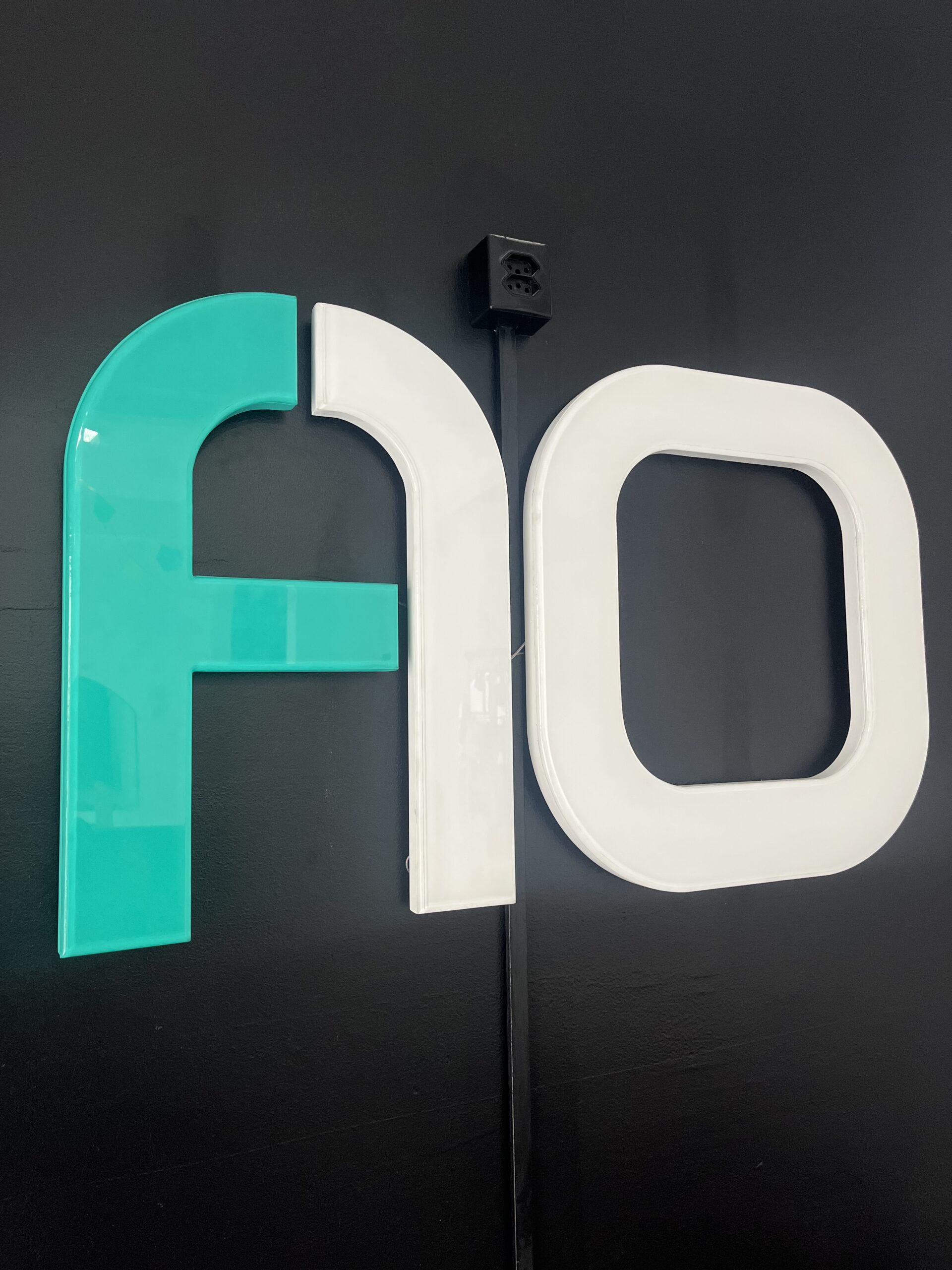 Letreiro em Acrílico com Iluminação Interna – Fachada A10Neste projeto, desenvolvemos um letreiro em acrílico com iluminação interna em LED para a marca A10. As letras foram produzidas em acrílico de alto brilho, combinando as cores branco e verde, resultando em um visual moderno, limpo e marcante.
Instalado sobre uma parede preta, o letreiro ganha ainda mais destaque, valorizando a identidade visual da empresa e transmitindo sofisticação e profissionalismo. A iluminação em LED garante excelente visibilidade, baixo consumo de energia e longa durabilidade.
Esse tipo de sinalização é ideal para ambientes internos, recepções, escritórios e espaços comerciais que buscam reforçar a presença da marca com elegância e impacto visual.